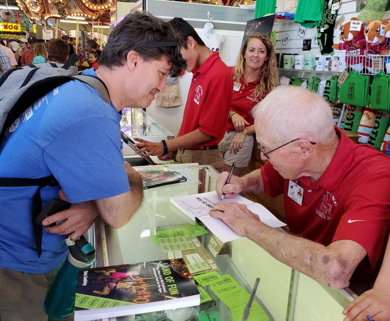 Al Fasnacht brings a smile to the face of this Funland customer while signing a new book on the history of the amusement park. CHRIS FLOOD PHOTOS